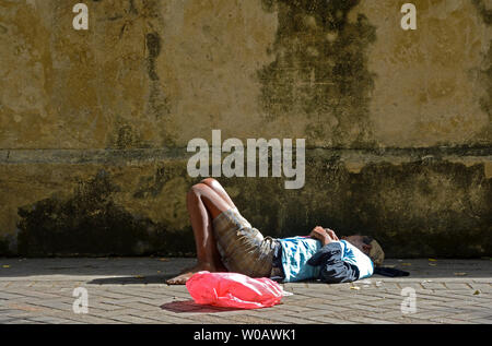 Santo Domingo, Repubblica dominicana - 2014.02.26: senzatetto dormire di fronte a un muro di fronte di fronte Cattedrale Santa Maria la Menor in ci Foto Stock