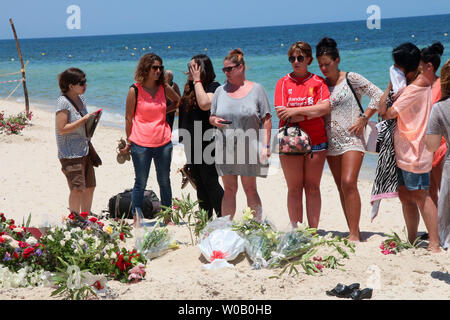 I turisti pagano i loro aspetti di fronte un ripiego memorial presso la spiaggia vicino al Imperial Marhaba resort che è stato attaccato da un bandito in Sousse, Tunisia, 29 giugno 2015.Lo Stato islamico (ISIS) gruppo rivendicato la responsabilità per il massacro perpetrato il 27 giugno in un mortale beach resort attentato che ha ucciso quasi 40 persone, la maggior parte di essi turisti britannici. Foto di Khaled Nasraoui/UPI Foto Stock