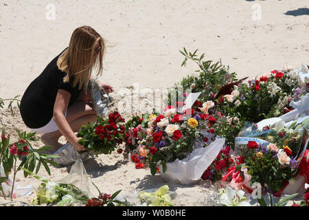 I turisti pagano i loro aspetti di fronte un ripiego memorial presso la spiaggia vicino al Imperial Marhaba resort che è stato attaccato da un bandito in Sousse, Tunisia, 29 giugno 2015.Lo Stato islamico (ISIS) gruppo rivendicato la responsabilità per il massacro perpetrato il 27 giugno in un mortale beach resort attentato che ha ucciso quasi 40 persone, la maggior parte di essi turisti britannici. Foto di Khaled Nasraoui/UPI Foto Stock