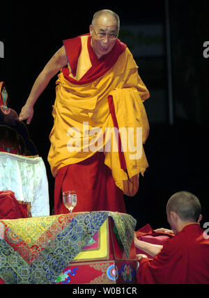 Sua Santità il XIV Dalai Lama ascende il suo trono prima di parlare a un pubblico di mattina di 13.000, frequentando il suo insegnamento spirituale sessione sulla natura della compassione e i modi di coltivare un buon cuore di Vancouver's Pacific Coliseum sul secondo dei quattro giorni di visita, Aprile 18, 2004. (UPI foto/H. Ruckemann) Foto Stock