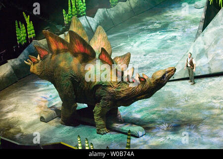 Un armor Stegosaurus placcato dal giurassico si muove oltre Huxley il paleontologo giocato da Jonathan Bliss durante i novanta minuti di Walking with Dinosaurs - l'esperienza live show a GM Place di Vancouver, British Columbia, 31 gennaio 2008. Burattinai e animatronici ricreare quindici vita come creature rappresentano dieci specie che copre l'intero 200 milioni di anni di regno dei dinosauri in mostra che è in tournée in America del Nord basati sulla pluripremiata serie televisiva BBC. (UPI foto/Heinz Ruckemann) Foto Stock