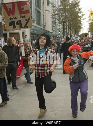 Diverse centinaia di rumorosi e pittoreschi "Occupare Vancouver' contestatori marzo a sostegno della "Robin Hood Tax" attraverso il centro cittadino di Vancouver, Columbia Britannica il 29 ottobre 2011, due giorni prima di Halloween. La tassa sul prelievo di un per cento della tassa sui profitti delle banche e cambio valuta straniera. UPI/Heinz Ruckemann Foto Stock