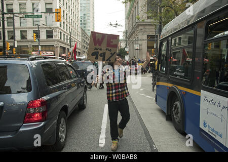 Diverse centinaia di rumorosi e pittoreschi "Occupare Vancouver' contestatori disturbare il traffico come essi marzo a sostegno della "Robin Hood Tax" attraverso il centro cittadino di Vancouver, Columbia Britannica il 29 ottobre 2011, due giorni prima di Halloween. La tassa sul prelievo di un per cento della tassa sui profitti delle banche e cambio valuta straniera. UPI/Heinz Ruckemann Foto Stock