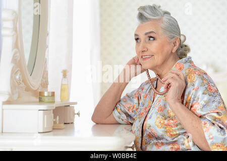Ritratto di felice donna senior di applicare il trucco Foto Stock