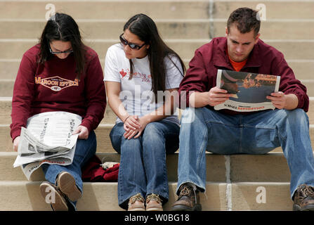 Virginia Tech senior Emily Wold (L) di Rochester, New York, senior Michelle Falletti (C) di Chantilly, Virginia e senior Sean Ek di Pittsburgh, Pennsylvania, leggere storie nel collegio il giornale, la collegiata volte, circa il 33 studenti che sono morti in due incidenti di tiro sul campus in precedenza questa settimana a Blacksburg, Virginia, 18 aprile 2007. La ripresa è più letali in un campus della scuola nella storia degli Stati Uniti. (UPI foto/Saul Loeb) Foto Stock