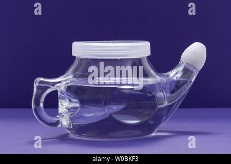 Neti Pot con Soft Comfort punta isolata su sfondo viola. Lavaggio del seno. Irrigazione nasale. Foto Stock