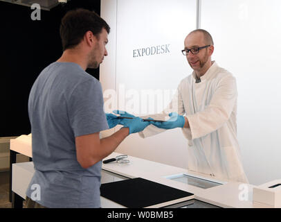 24 giugno 2019, Baden-Wuerttemberg, Karlsruhe: Alexander Wolny (r), chief illustrativa di della mostra "Archäologie in Baden - Expothek¹' (archeologia in Baden - Expothek¹) presenta un oggetto, una spada dalla età del Bronzo datato 1300-1200 BC, per un utente al Badisches Landesmuseum nel castello di Karlsruhe. La mostra sarà aperta dal 13 luglio 2019. Dalla spada dall'età del bronzo di preziosi gioielli - nel laboratorio del museo delle parti interessate può guardare intorno 1500 oggetti storici sulla base di un catalogo digitale e su richiesta anticipata - e in alcuni casi anche tenere nelle loro mani. (Per d Foto Stock