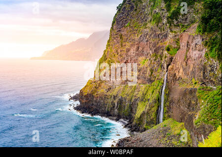 Bella costa selvaggia scenario vista con Bridal Veil Falls (Veu da noiva) a Ponta do Poiso nell'isola di Madeira. Nei pressi di Porto Moniz, Seixal, Portogallo. Foto Stock