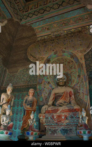 Statue di Buddha e murales nelle grotte di Dunhuang Foto Stock