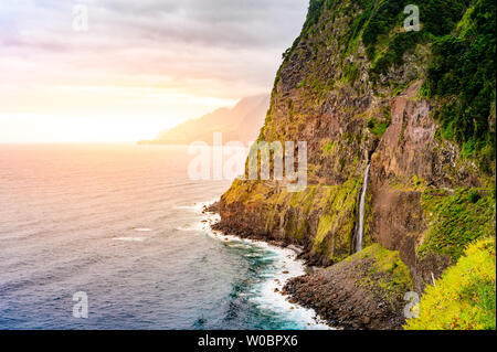 Bella costa selvaggia scenario vista con Bridal Veil Falls (Veu da noiva) a Ponta do Poiso nell'isola di Madeira. Nei pressi di Porto Moniz, Seixal, Portogallo. Foto Stock