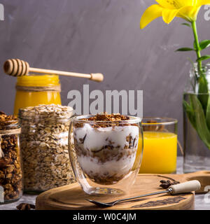 Il dessert con cereali e yogurt in bicchieri con doppio vetro per la prima colazione Foto Stock