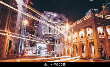 Semaforo sentieri correre attraverso il Central & Admiralty distretto nel cuore di Hong Kong di aree di business di notte. Foto Stock