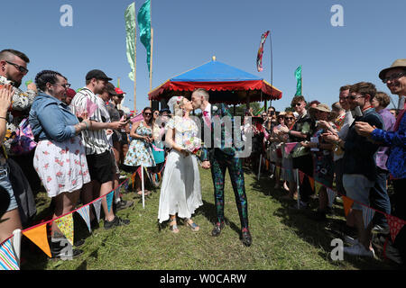 Una celebrazione di matrimonio per Jack Watney, 32 e Sarah Adey, 31, presso il Croissant Neuf bandstand nel verde dei campi area del festival di Glastonbury presso l'azienda agricola degna, Pilton, Somerset. Foto Stock