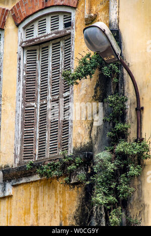 Finestra chiusa con lampada di strada sulla vecchia facciata della casa. Foto Stock