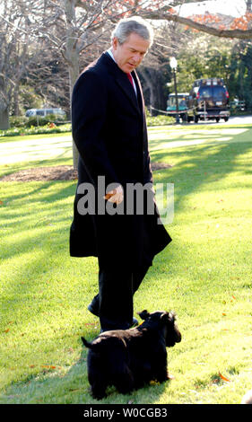 Il Presidente George W Bush passeggiate attraverso il South Lawn della Casa Bianca chiamando suo cane Barney, dopo che arrivano dalla sua prima visita ufficiale in Canada, il 1 dicembre 2004 a Washington. Bush ha discusso l'importanza di buone relazioni commerciali con gli Stati Uniti il più grande partner commerciale e ha provato a liscia su qualsiasi relazione danneggiata a causa della guerra in Iraq. (UPI foto/Michael Kleinfeld) Foto Stock