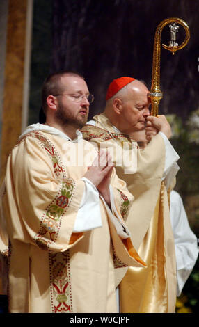 Theodore McCarrick, Arcivescovo di Washington, DC, a destra conduce una cerimonia di massa a St. Matthews Cattedrale di Washington il 3 aprile 2005. McCarrick ha parlato della morte di Papa Giovanni Paolo II, che muore il 2 aprile, dicendo che è stato fonte di ispirazione non solo per i cattolici, mettere a quelle della fede in tutto il mondo. L'ottantaquattro anni di Pontefice morì dopo la sofferenza del cuore e insufficienza renale. (UPI foto/Michael Kleinfeld) Foto Stock