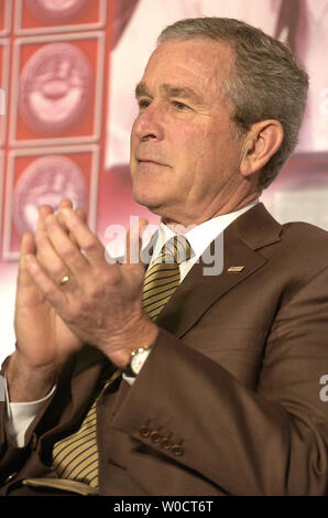 Il Presidente degli Stati Uniti George W. Bush applaude come egli ascolta il commento di first lady Laura Bush alla Casa Bianca Conferenza su aiutare l'America a favore della gioventù, Ottobre 27, 2005 a Howard University di Washington. In precedenza Bush ha accettato di Harriet Miers" la decisione di ritirare la sua corte suprema nomina. (UPI foto/Mike Theiler) Foto Stock