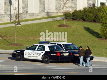 Gli ufficiali di polizia vegliare su un ingresso al Virginia Polytechnic Institute and State University, dove almeno 33 persone sono morte in due incidenti di tiro in campus Blacksburg, Virginia, il 16 aprile 2007. Questa ripresa a Virginia Tech è la più mortale in un campus della scuola nella storia degli Stati Uniti. (UPI foto/Roger L. Wollenberg) Foto Stock