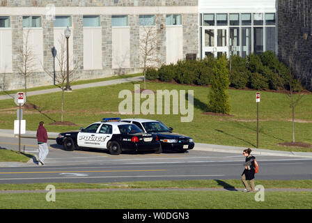 Gli ufficiali di polizia vegliare su un ingresso al Virginia Polytechnic Institute and State University, dove almeno 33 persone sono morte in due incidenti di tiro in campus Blacksburg, Virginia, il 16 aprile 2007. Questa ripresa a Virginia Tech è la più mortale in un campus della scuola nella storia degli Stati Uniti. (UPI foto/Roger L. Wollenberg) Foto Stock