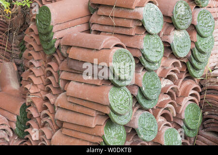 Verde fiore in rilievo modello ceramico su tegole del tetto. Foto Stock