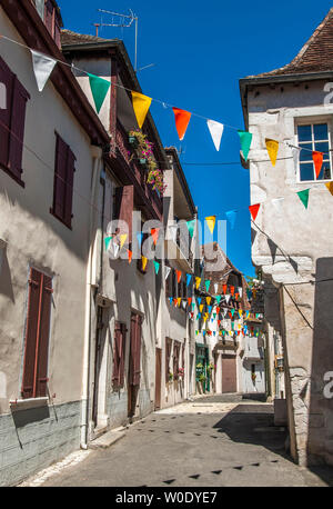 Francia, Pyrenees-Atlantiques, Salies-de-Bearn, stretta strada fiancheggiata da case tradizionali Foto Stock