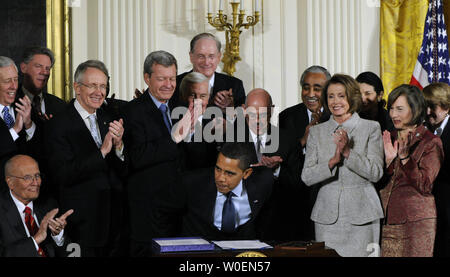 I membri del Congresso di applaudire dopo Stati Uniti Il presidente Barack Obama ha firmato lo stato della salute dei bambini programma assicurativo (SCHIP) bill nella Sala Est della Casa Bianca a Washington il 4 febbraio 2009. Il disegno di legge si espande SCHIP da circa $ 35 miliardi di euro per cinque anni e sarà finanziato con un 62-cento-per-pack aumento della Tassa federale sulle sigarette. (UPI foto/Alexis C. Glenn) Foto Stock