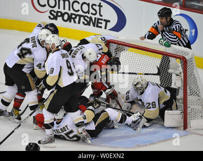 Washington capitelli Chris Clark (17) viene arrestato dai membri dei pinguini di Pittsburgh come egli tenta di mettere il puck pass goalie Marc-andré Fleury durante il terzo periodo al Verizon Center di Washington il 4 maggio 2009. (UPI foto/Kevin Dietsch) Foto Stock