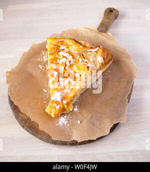 Gustosi piatti fatti in casa frutta cotta berry tart, torta o torta spolverato in stile country con piastra a mano di colore bianco a maglia shabby chick igienico. Delizioso pezzo di c Foto Stock