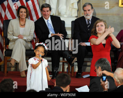 Malia Thibado, 4 anni, canta come Nichole Gordy interpreta con segni durante una cerimonia in cui una statua di Helen Keller è svelato nel Capitol Rotunda sul Campidoglio di Washington il 7 ottobre 2009. Sul palco da sinistra sono presidente della Camera Nancy Pelosi, D-CA, Alabama Gov. Bob Riley e La Fondazione Americana per i ciechi Presidente e Chief Executive Officer Carl Augusto. UPI/Roger L. Wollenberg Foto Stock