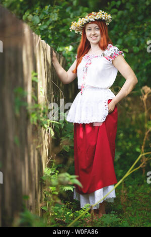 I Capelli rossi ragazza di campagna in un vestito tradizionale Foto Stock