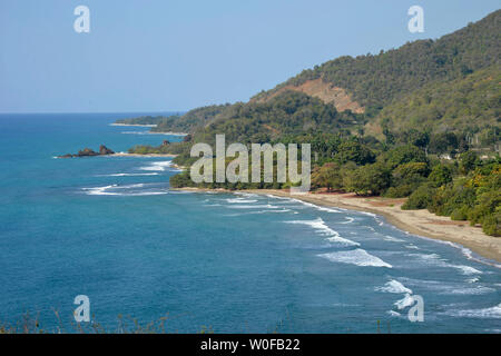 Cuba, regione orientale, il paesaggio di una costa selvaggia con vegetazione lussureggiante e turchese blu Foto Stock