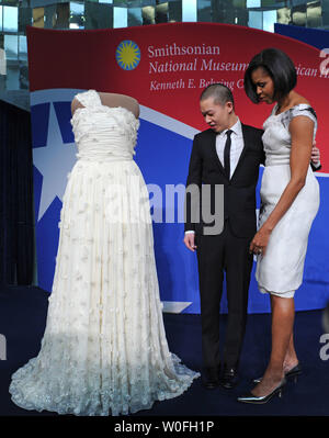 La First Lady Michelle Obama e fashion designer Jason Wu guardare il suo abito inaugurale in occasione di un evento in cui ella donò allo Smithsonian Museo Nazionale di Storia Americana della prima collezione donna, presso lo Smithsonian a Washington il 9 marzo 2010. UPI/Kevin Dietsch Foto Stock