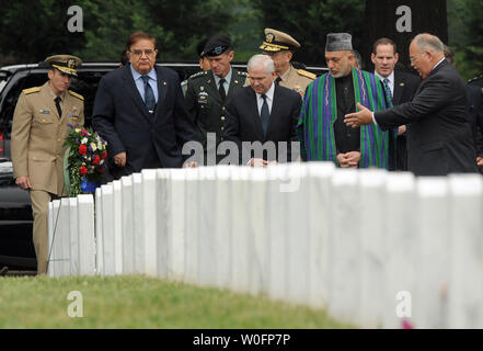 Afghanistan il presidente Hamid Karzai (RC), U.S. Il Segretario della Difesa Robert Gates (LC), comandante della forza internazionale di assistenza alla sicurezza e degli Stati Uniti Forces Afghanistan gen. Stanley McChrystal (L) e Presidente del Comune di capi di Stato Maggiore Adm. Michael Mullen (dietro cancelli) visualizza la tomba di esercito di SPC Andrew Ross McGinnis come essi tour sezione 60 di Al Cimitero Nazionale di Arlington con il Soprintendente John C. Metzer, Jr., (R) in Arlington, Virginia, il 13 maggio 2010. McGinnis morì il 4 dicembre 2006, come egli soffoca una granata gettata nel suo veicolo in Iraq e atto che gli è valso la medaglia d'onore. Setta Foto Stock