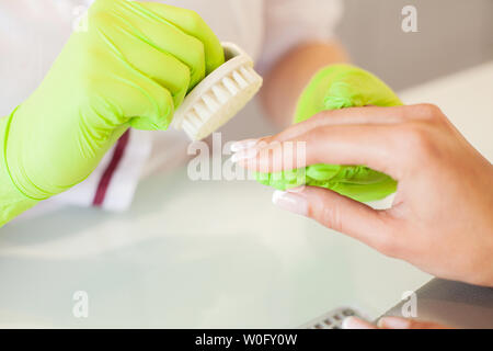 Manicure. Abile maestro di manicure file tiene nelle sue mani mentre si lavora nel suo salone di bellezza Foto Stock