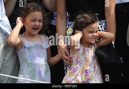 Due giovani visitatori coprire le loro orecchie come uno marino terre su South Lawn presso la Casa Bianca a Washington il 19 agosto 2010. Il presidente Barack Obama è di lasciare Washington per una vacanza in famiglia per il Vigneto di Martha. UPI/Kevin Dietsch Foto Stock