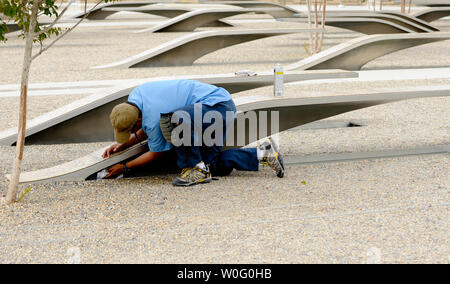 Un lavoratore pulisce i banchi che rappresentano il 184 vite perdute nel settembre 11, 2001 attacco terroristico contro il Pentagono al Pentagono Memorial in Arlington, Virginia, il 10 settembre 2010. UPI/Alexis C. Glenn Foto Stock