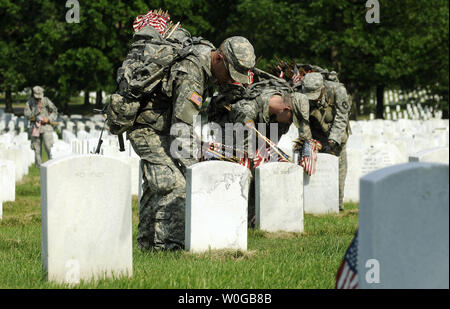 I soldati della US Army 3° Fanteria, vecchia guardia, pone una bandiera americana a una grave durante le bandiere in prima per il Memorial Day al Cimitero Nazionale di Arlington, in Arlington, Virginia, il 26 maggio 2011. UPI/Roger L. Wollenberg Foto Stock