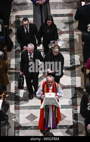 Il vescovo Gene Robinson porta i resti di Matthew Shepard, seguita da Shepards genitori e un fratello, Judy, Dennis e Logan Shepard, seguendo il suo memoriale di servizio presso la Cattedrale Nazionale di Washington il 26 ottobre 2018 a Washington, DC. Shepard fu assassinato nel Wyoming venti anni fa ed è quello di essere sepolto presso la National Cathedral. Foto di Leigh Vogel/UPI Foto Stock