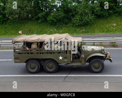 Un esercito di vintage veicolo su una strada in Normandia in rotta per una commemorazione del D-Day Foto Stock