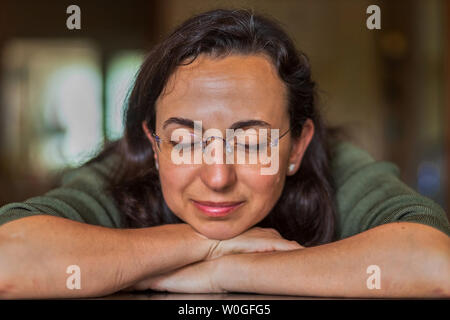 Bella donna spagnola con gli occhiali a casa nella parte anteriore della fotocamera Foto Stock