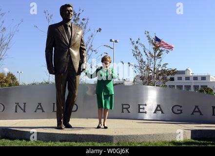 Elizabeth Dole, ex segretario di trasporto sotto Reagan, trattiene la mano di un 9 piedi di altezza, 900-pound statua in bronzo del Presidente Ronald Reagan, dopo l'inaugurazione da Ronald Reagan Presidential Foundation come parte del Reagan la celebrazione del centenario, all'Aeroporto Nazionale Ronald Reagan di Washington in Arlington, Virginia, il 1 novembre 2011. UPI/Roger L. Wollenberg Foto Stock