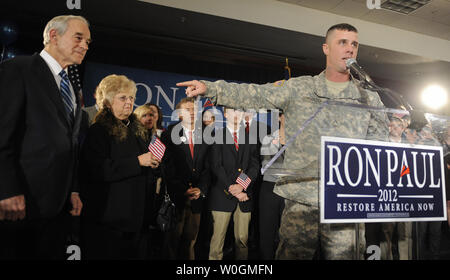 US Army Cpl. Jesse Thorsen punti per il repubblicano 2012 candidato presidenziale e del Texas sost. Ron Paul con sua moglie Carol dopo essere stato invitato a fare il commento da Paolo in un rally in Ankeny, Iowa, dopo Paolo finitura forte nello Iowa's first-in-la-nazione Caucaso, 3 gennaio 2012. Con voti ancora necessari per essere contato, Paolo fu un terzo vicino alla parte superiore unità di finitura ex Massachusetts Gov. Mitt Romney ed ex senatore della Pennsylvania Rick Santorum. UPI/Mike Theiler Foto Stock