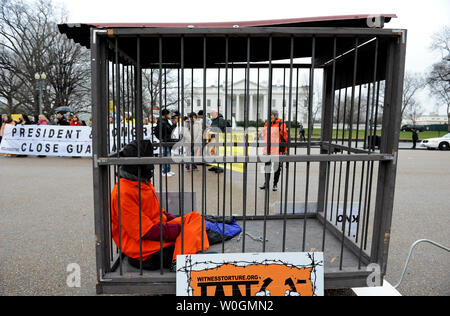 Protester si siede in una gabbia per segnare il decimo anniversario della apertura della baia di Guantanamo il campo di detenzione, di fronte alla Casa Bianca a Washington il 11 gennaio 2012. Sui diritti umani di gruppi in tutto il mondo sono esigenti il camp essere chiuso. Dei quasi 800 detenuti presi a Guantanamo, 171 prigionieri rimangono. UPI/Pat Benic Foto Stock