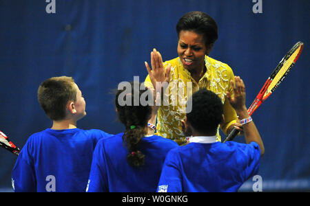 La First Lady Michelle Obama si congratula con i bambini della scuola dopo aver giocato a tennis con loro a un mini-Olimpiadi evento con Samantha Cameron, la moglie del Regno Unito il Primo Ministro David Cameron, presso l'American University a Washington D.C. il 13 marzo 2012. UPI/Kevin Dietsch Foto Stock