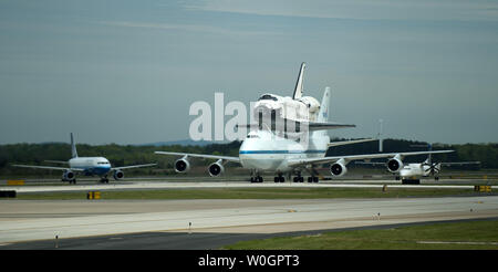 Lo Space Shuttle Discovery, equitazione sopra di NASA 747 vettore navetta aerei, taxi sulla pista dopo l'atterraggio all'Aeroporto Internazionale di Dulles a Chantilly, Virginia il 17 aprile 2012. Discovery, che si è conclusa è ultima missione il 9 marzo 2011, è stato messo in esposizione permanente presso il Smithsonian nazionale dell'aria e dello spazio MuseumÍs Udvar-Hazy Center in Chantily, Virginia. UPI/Kevin Dietsch Foto Stock