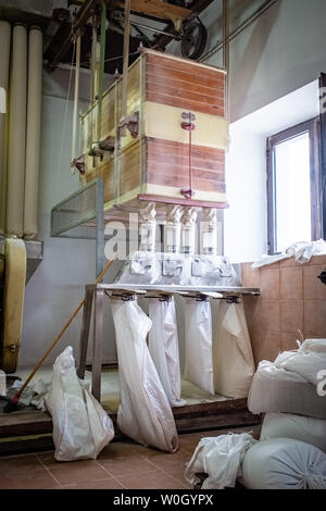 NOCI, Italia - 29 settembre 2018: frumento processo di macinazione in un materiale elettricamente alimentato vecchio mulino Foto Stock
