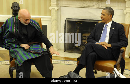 Il Presidente Usa Barack Obama (R) ascolta il Presidente afgano Hamid Karzai che gesti durante un incontro bilaterale nell'Ufficio Ovale della Casa Bianca, 11 gennaio 2013, a Washington, DC. I leader si stanno discutendo di un accordo a lungo termine su di noi la presenza di truppe americane come le forze militari guardare un 2014 data di ritiro dall'Afghanistan. UPI/Mike Theiler Foto Stock