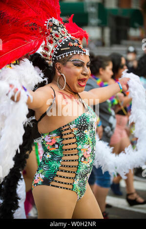 NEW YORK CITY - Giugno 25, 2017: Un transgender drag performer indossa un fiammeggiante costume di piume nel bilancio annuale Gay Pride Parade in Greenwich Village. Foto Stock