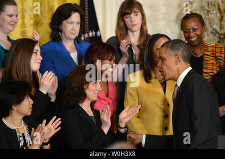 Carol Metcalf (C) è accolto dal Presidente Barack Obama dopo che egli si è discusso di come la sua firma il programma sanitario è che già beneficiano di milioni di americani durante un evento nella Sala Est della Casa Bianca di Washington il 10 maggio 2013. Carol Metcalf notare come la nuova legge ha permesso il suo figlio Justin per rimanere sulla sua assicurazione come egli recupera da una lesione cerebrale. Principali disposizioni della la cura a prezzi accessibili, talvolta chiamato Obamacare, per assicurare che il veicolo non assicurato entreranno in vigore a sei mesi. UPI/Pat Benic Foto Stock