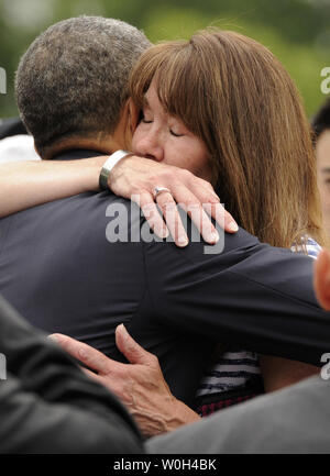 Il Presidente Usa Barack Obama abbracci sposare Ellen Callahan di Hanson, Massachusetts, il cui figlio USMC SSGT William Callahan è stato ucciso in Iraq nel 2007, mentre la visita con le famiglie presso il Cimitero Nazionale di Arlington del Memorial Day, in Arlington, Virginia, 27 maggio 2013. Il Memorial Day la nazione onora i suoi veterani militari e di coloro che sono morti nel paese di conflitti. UPI/Mike Theiler Foto Stock